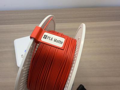 Filament spool clip with label slot