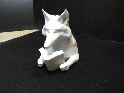 Bust of wolf reading a book.