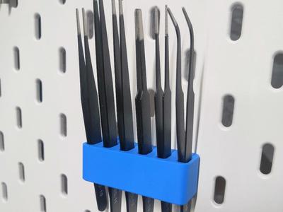Holder for tweezers on a Skadis board.