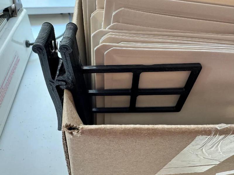 Box hold back clip
