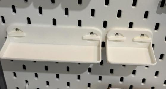 This shelf is made for Ikea pegboards and includes two shelves with dimensions of 152mm width and 71mm width with 40mm depth, along with fastening tools.