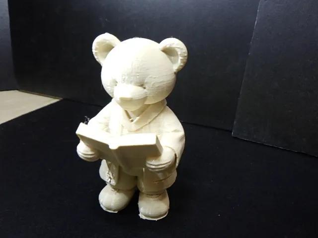 A cute teddy bear in robe reading a book #2.   