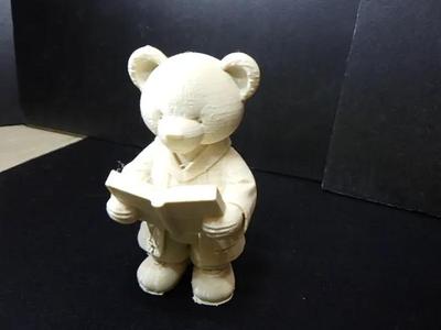 A cute teddy bear in robe reading a book #2.   