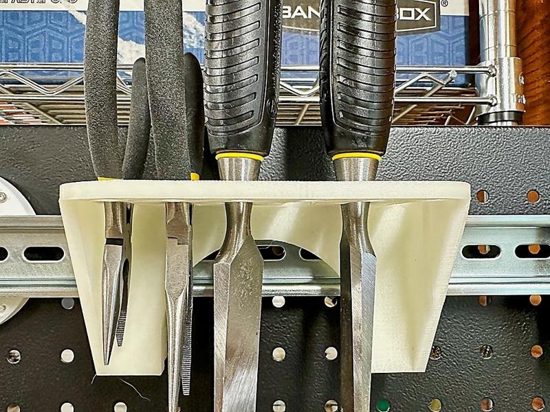 A DIN rail mounting bracket to hold chisels, pliers, scissors, and other such things